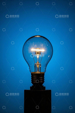 蓝色背景下发光的复古灯泡