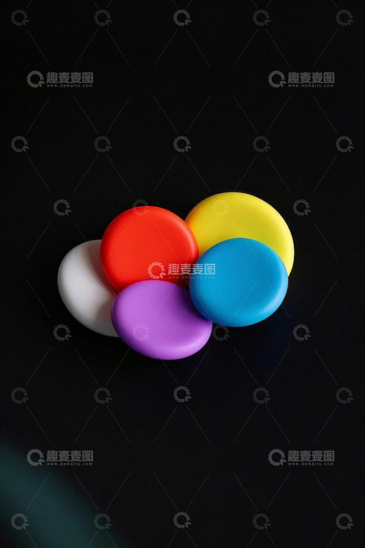 多彩圆形物体摆放在黑色背景上
