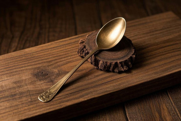 木桌上放置的金属勺子特写
