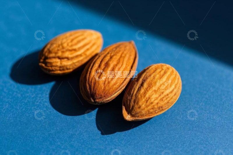 高清大图下载【趣麦麦图】蓝色背景上的三颗杏仁
