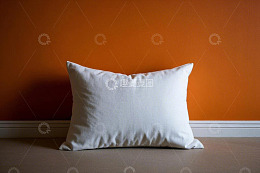 橙色墙前的白色抱枕