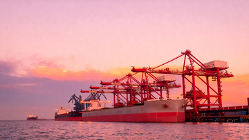 港口红吊车旁货轮映粉霞