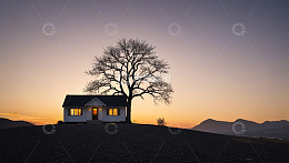 黄昏时山丘上的小屋与孤树