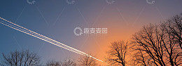 夕阳下飞机划过天空