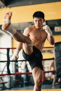 男性健身房内练习踢腿动作