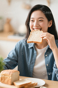 年轻女子餐桌前吃面包画面