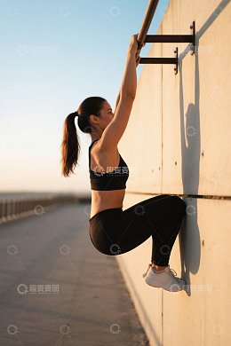 户外女子做引体向上健身