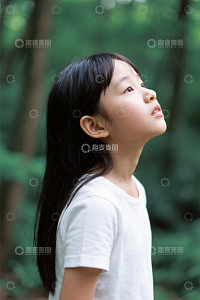 户外树林中仰头的小女孩