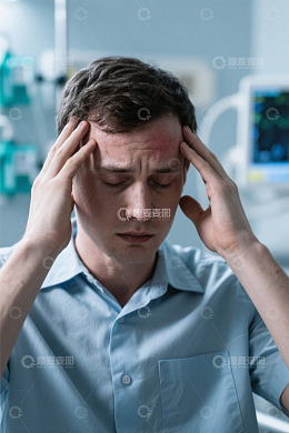 男人双手抱头面露痛苦