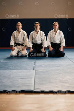 三个年轻女子身穿武术服席地而坐