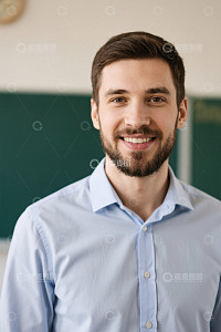 微笑的年轻男老师站在教室里