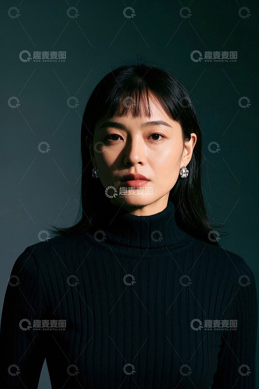 一位亚洲女性身穿黑色高领毛衣凝视前方