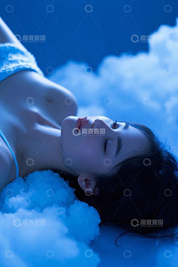 闭眼躺卧在云朵上的年轻女性