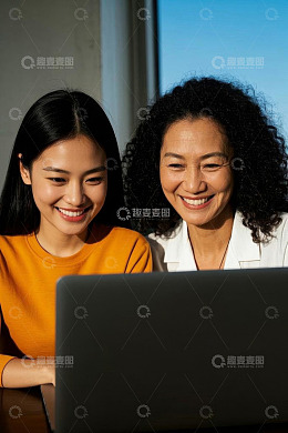 两位女性共同查看笔记本电脑