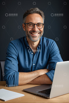 微笑男士办公桌前用笔记本电脑