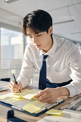商务男士办公桌前书写便签