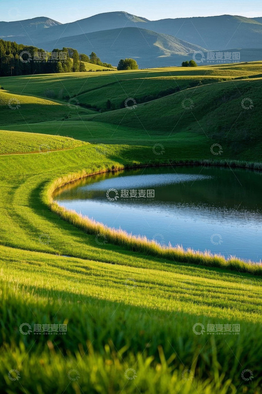 绿色山丘间的静谧湖泊风光