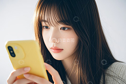 年轻女性手持黄色手机