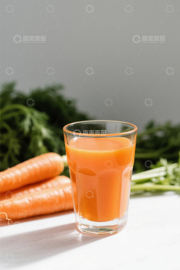 玻璃杯装胡萝卜果汁及胡萝卜
