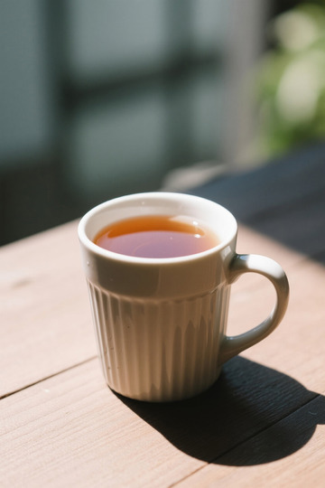 木桌上的白色杯装茶饮