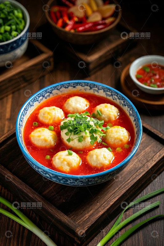碗装肉丸配红色汤汁与葱花