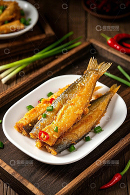 盘中油炸小鱼配葱和辣椒