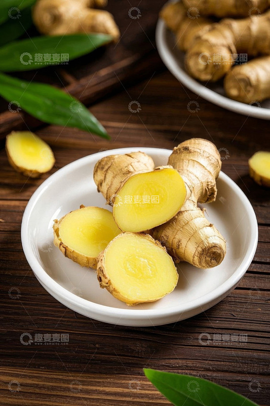木桌上白盘内的新鲜生姜