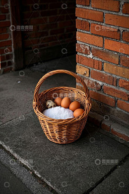 砖墙旁篮子里的鸡蛋和鹌鹑蛋