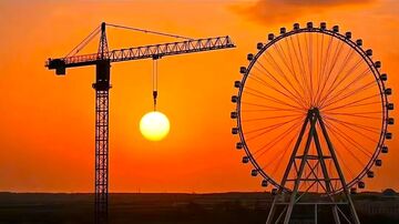 摩天轮与起重机夕阳美景