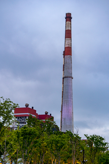 杨浦发电厂工业风烟囱与绿树对比摄影