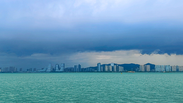 写实风乌云密布城市上空海景建筑群摄影素材