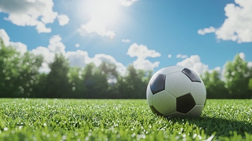 阳光下绿茵场上的足球