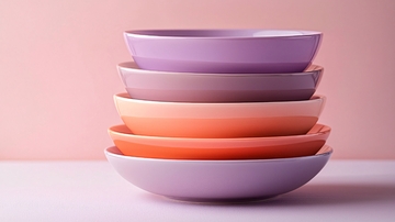 粉色背景下叠放的彩色碗