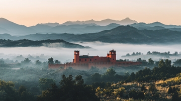 山峦晨雾中的红砖城堡