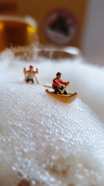 微型人物在泡沫上划船
