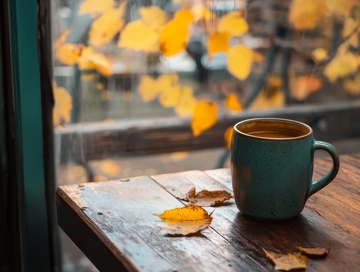 窗边的咖啡杯与秋叶