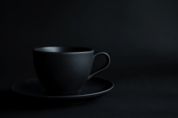 黑色背景下的简约咖啡杯