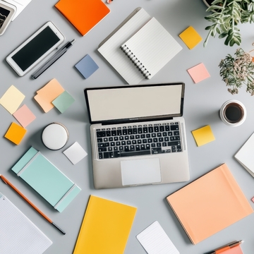 办公桌面布局，笔记本电脑与文具