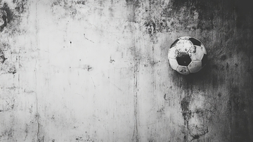 黑白足球静置于粗糙地面