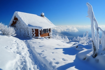雪覆山间小屋，晴空万里