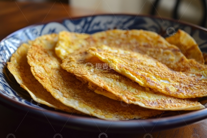 高清大图下载【趣麦麦图】金黄色煎饼叠放在蓝色花纹碗中