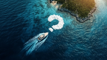 游艇驶过海面，留下问号形状尾迹