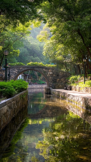 石桥横跨绿树成荫的水道