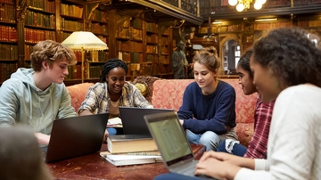 学生在图书馆使用笔记本电脑学习