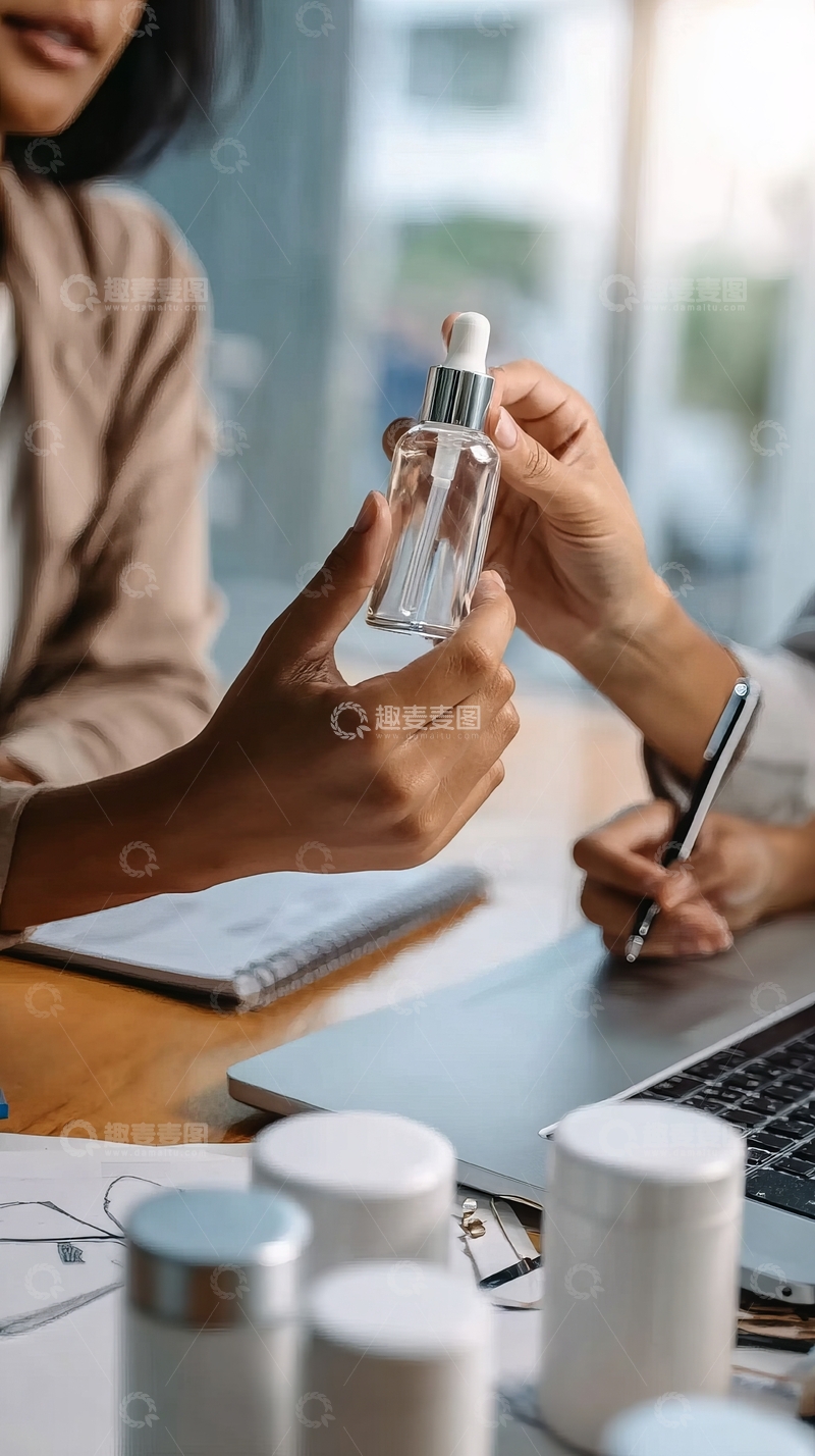 高清大图下载【趣麦麦图】两人在办公桌前讨论透明滴管瓶内的产品