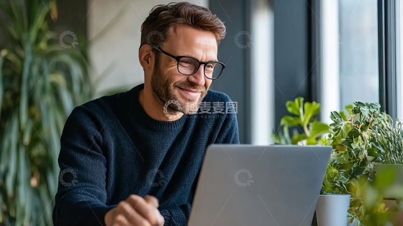 高清大图下载【趣麦麦图】-戴眼镜的男子在室内使用笔记本电脑微笑