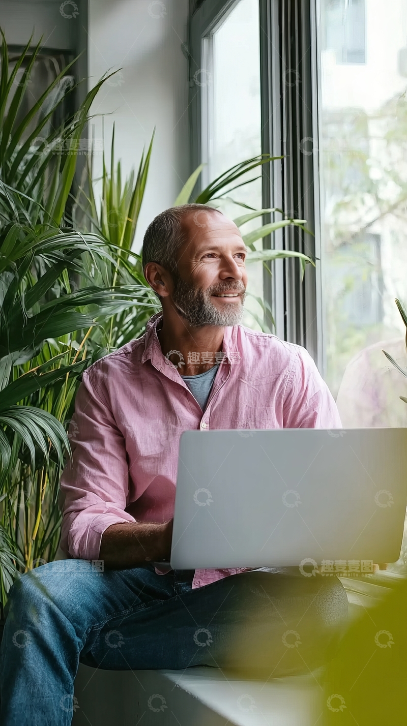 高清大图下载【趣麦麦图】中年男子在窗边使用笔记本电脑并望向窗外