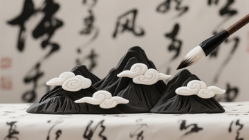 毛笔轻触黑山白云雕塑背景为书法