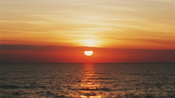 海上日落时分天空呈现橙黄色渐变色彩