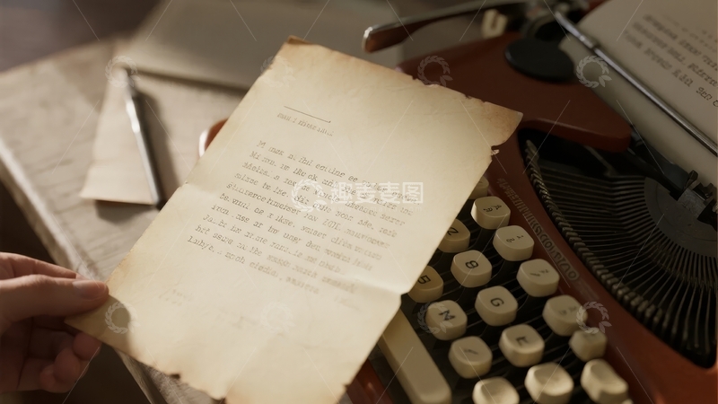 高清大图下载【趣麦麦图】手持旧信纸置于复古打字机旁的场景
